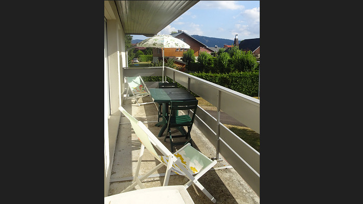 Le balcon en été le long du séjour et de la chambre